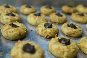 kaas vingerafdruk koekjes met chocola vulling, vingerafdruk koekjes vers van de oven Aan de aluminium pan foto