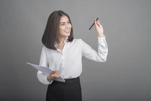 zakenvrouw in wit overhemd op grijze achtergrond foto