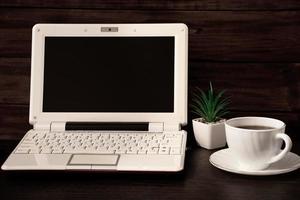 werkruimte aan huis. laptop en koffiekopje op houten achtergrond. plaats voor tekst.