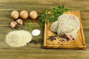 kalfsvlees milanees gepresenteerd Aan de tafel met ingrediënten foto