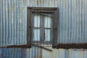 oud venster in typisch bouw in de stad- van puerto piramides, schiereiland valdes, chubut provincie, Patagonië, Argentinië. foto