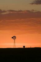 windmolen in platteland Bij zonsondergang, pampa, patagonië, argentinië. foto