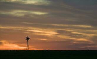 windmolen in platteland Bij zonsondergang, pampa, patagonië, argentinië. foto