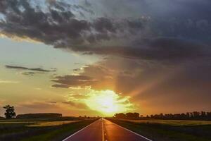 landschap met weg en stormachtig lucht Bij zonsondergang foto