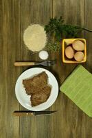 kalfsvlees milanees gepresenteerd Aan de tafel met ingrediënten foto
