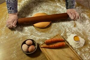 grootmoeder handen kneden deeg voor noedels in de keuken. foto