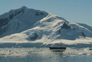 reis schip het zeilen in voorkant van antarctisch bergen, paradijs baai, Antarctica. foto