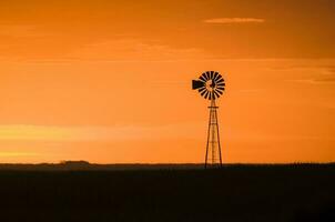 windmolen in platteland Bij zonsondergang, pampa, patagonië, argentinië. foto