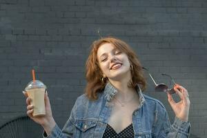 glimlachen vrouw met ijs latte koffie naar Gaan buitenshuis foto