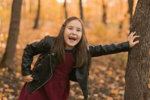 herfst emotioneel portret van lachend kind wandelen in park of Woud foto