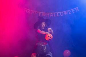 grappig kind meisje in heks kostuum voor halloween met pompoen krik. foto