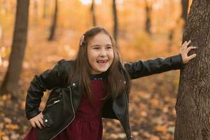 herfst emotioneel portret van lachend kind wandelen in park of Woud foto