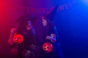 grappig kind meisje en vrouw in heksen kostuums voor halloween met pompoen jack foto