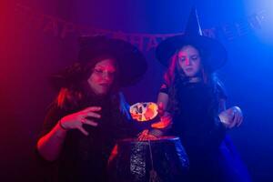 twee halloween heksen maken een toverdrank en toveren in halloween nacht. magie, vakantie en mysticus concept. foto