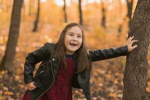 herfst emotioneel portret van lachend kind wandelen in park of Woud foto