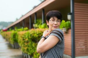 detailopname portret van mooi vrouw staand Aan de straat terwijl op zoek Bij camera en glimlachen foto