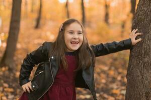 herfst emotioneel portret van lachend kind wandelen in park of Woud foto