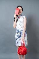 aziatische vrouw draagt chinese traditionele kleding met rode envelop of rood pakje foto