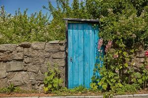 stenen muur en blauwe deur op het eiland Bornholm in Svaneke, Denemarken foto