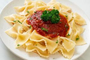 farfalle pasta in tomatensaus met peterselie - italiaans eten foto