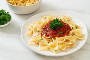 farfalle pasta in tomatensaus met peterselie - italiaans eten foto