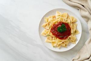 farfalle pasta in tomatensaus met peterselie - italiaans eten foto