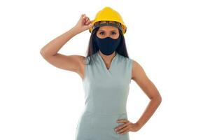 portret van Aziatisch ingenieur vrouw met helm vervelend een gezicht masker geïsoleerd wit achtergrond foto