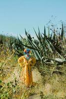 Mexicaans vrouw in kleurrijk jurk en schedel bedenken in de Mexicaans woestijn foto