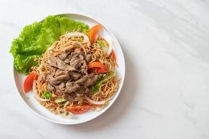 Instant noodle pittige salade met varkensvlees op een witte plaat - Aziatische voedselstijl foto