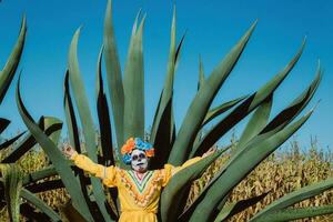 Mexicaans vrouw in kleurrijk jurk en schedel bedenken in de Mexicaans woestijn cactus foto