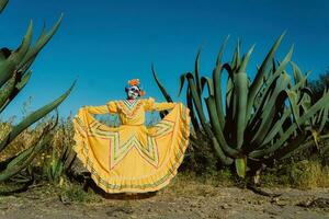 Mexicaans vrouw in kleurrijk jurk en schedel bedenken in de Mexicaans woestijn cactus foto