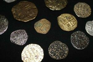 goud en zilver munten gelegd uit Aan Scherm. foto