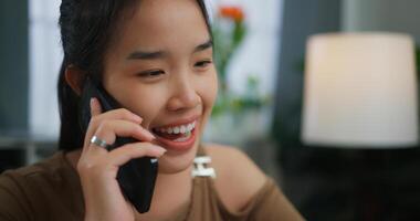Aziatisch gelukkig vrolijk jong vrouw pratend Aan de telefoon foto