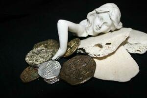 meermin houdende Aan schelpen aanraken munten van een schat borst. foto