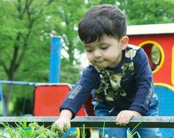 schattig Aziatisch Pakistaans baby is genieten van de mooi zonnig dag Bij afweren kinderen en openbaar park van luton stad- van Engeland uk. laag hoek beeld was gevangen genomen Aan april 03e, 2023 foto