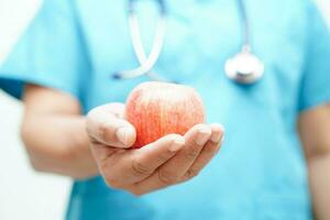 Aziatisch voedingsdeskundige Holding appel gezond voedsel voor geduldig in ziekenhuis, voeding en vitamine. foto