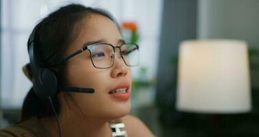 jong Aziatisch vrouw vervelend bril gebruik makend van een laptop Aan een bureau foto