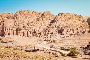 toeristen wandelen bezoek petra historisch mijlpaal in Jordanië Aan zomer met toneel- panorama van heilig graven foto