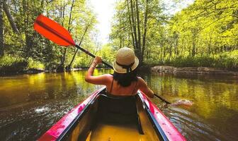 terug visie kajakken paar in rivier. pov van vrouw en Mens kajakken in mooi landschap. aquatisch sport- gedurende vallen herfst concept.mooi kalmte ontspannende warm toneel- bomen herfst foto