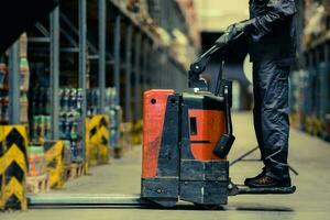 arbeider bezig met laden pallet met pallet jack foto