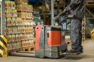 arbeider bezig met laden pallet met pallet jack foto