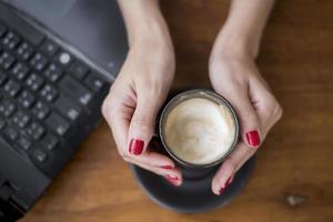 vrouw met warme cappuccino op bureau office
