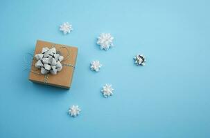 bruin plein doos met een geschenk gebonden lint met een boog Aan een blauw achtergrond foto