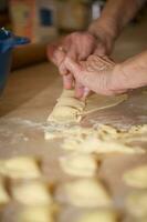 oud vrouw is voorbereidingen treffen eigengemaakt ravioli met kaas foto