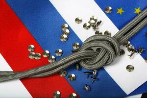touw met een knoop en pinnen Aan vlaggen van EU en Rusland. achtergrond foto