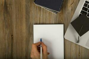 blanco vel van papier en menselijk hand- dichtbij naar de laptop. foto