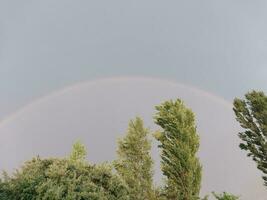 vol regenboog na regen tegen de lucht foto