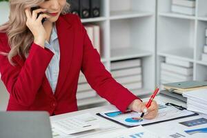 consultant, Aziatisch zakenvrouw werken Aan de telefoon wie discussie financieel werk en afzet bedrijf plan naar toenemen bedrijf winst, klaar naar gebruik computer en afzet planning documenten. foto