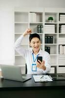 Aziatisch bedrijf Mens zijn verheugd en gelukkig met de werk ze Doen Aan hun tablet, laptop en nemen aantekeningen Bij de kantoor. foto