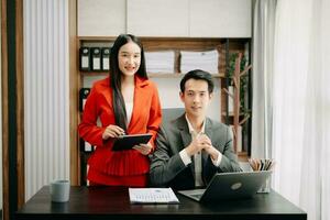 twee Aziatisch zakenvrouw bespreken investering project werken en planning strategie met tablet laptop computer in kantoor. foto